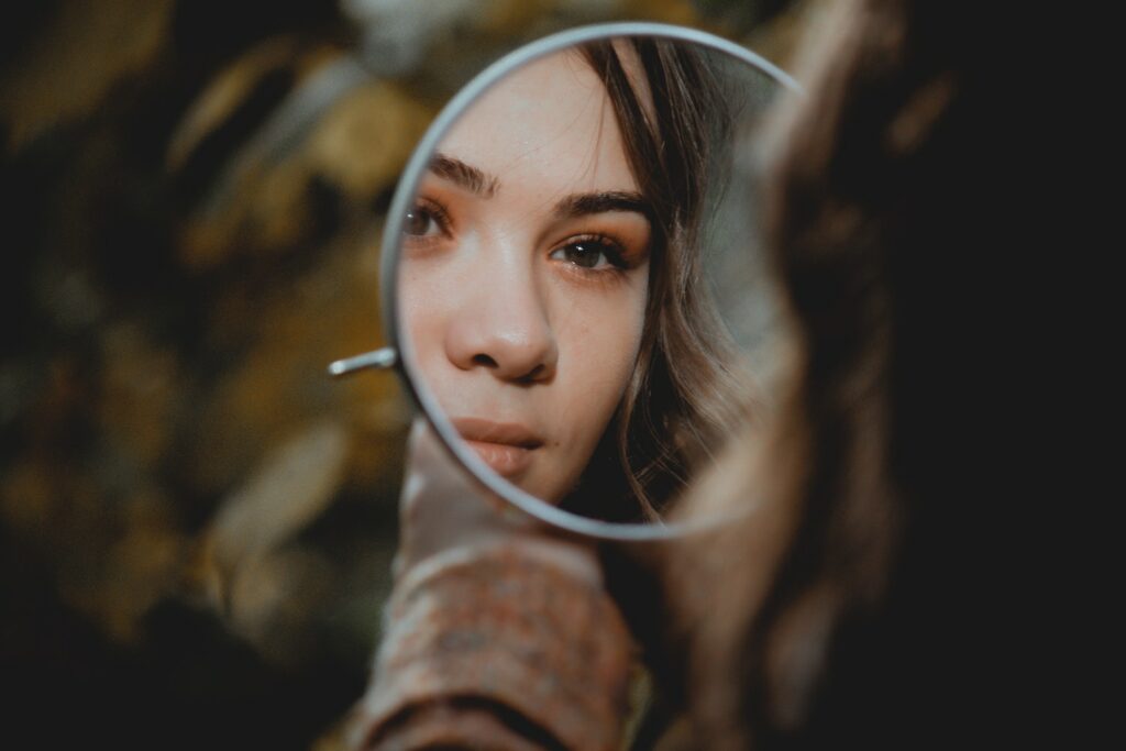 Young woman holding mirror